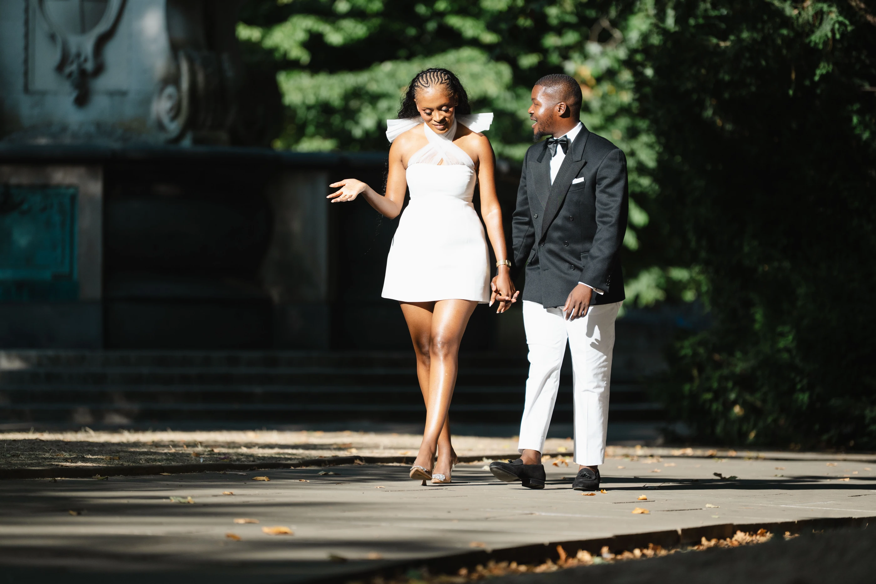 Kennedy and Didimalang walking hand in hand through a leafy garden
